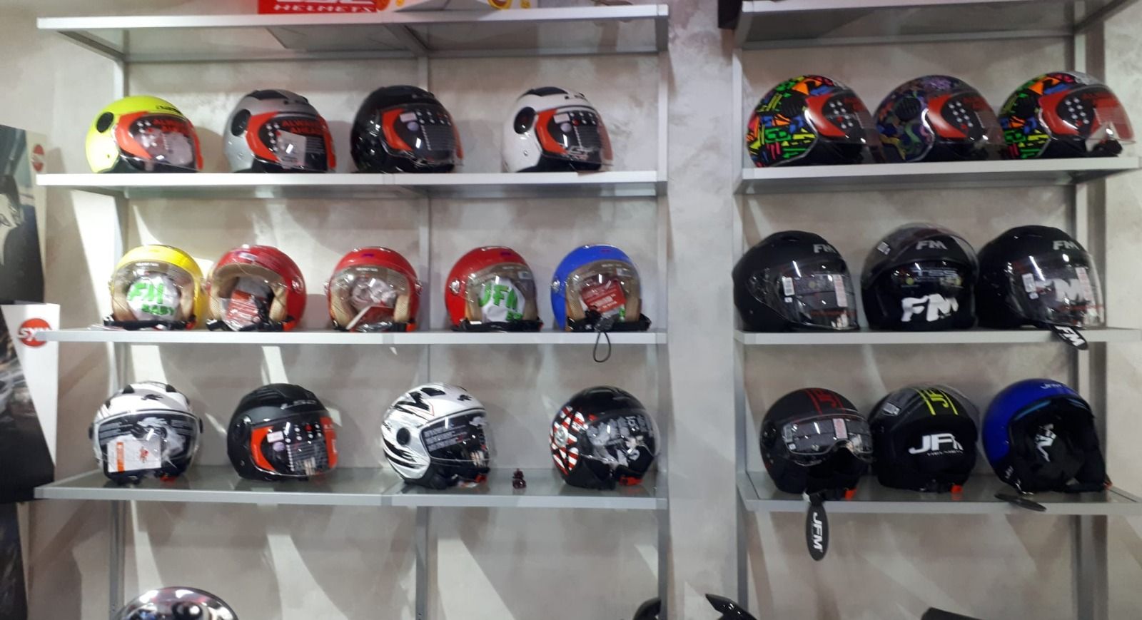 A display of motorcycle helmets on shelves in a store.