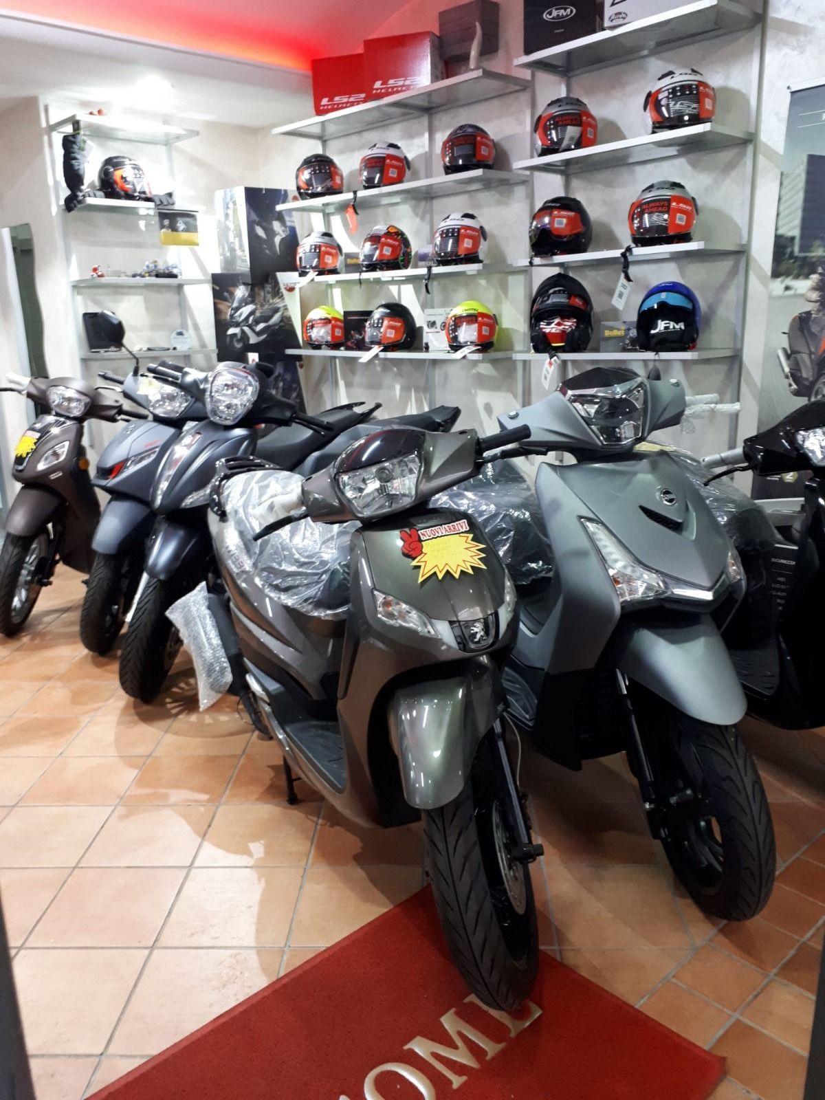 A row of motorcycles are parked in a showroom.
