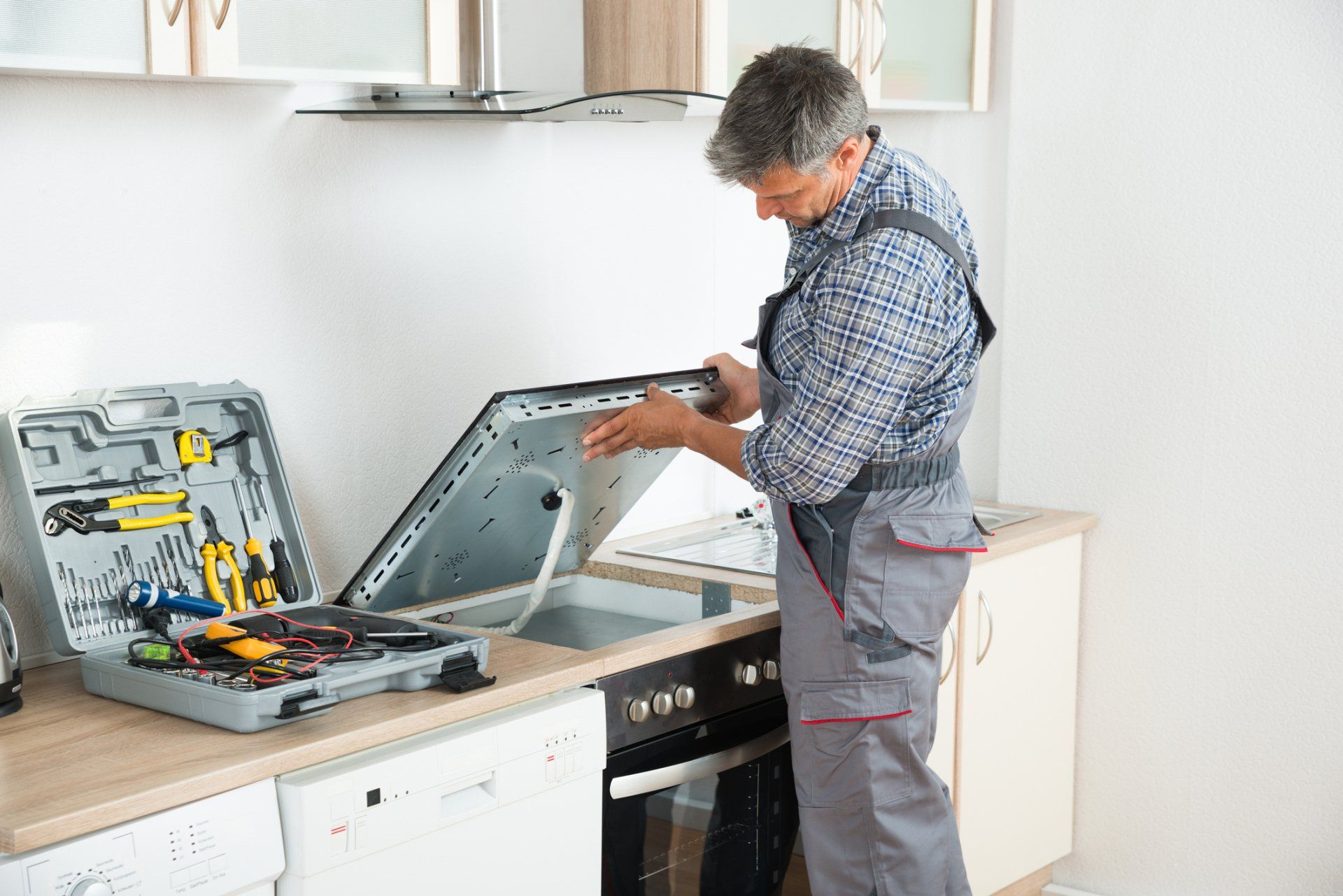 Repairman Examining Stove — Hendersonville, NC — Freedom Appliance