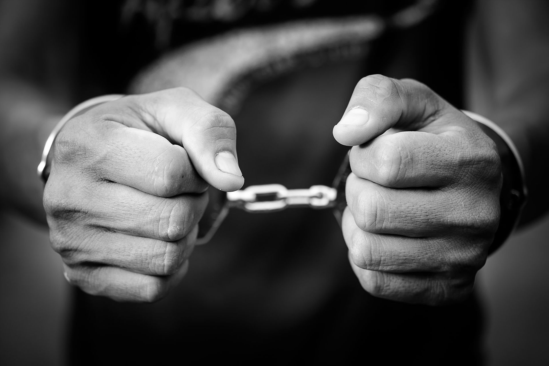 handcuffed man focuses his hand