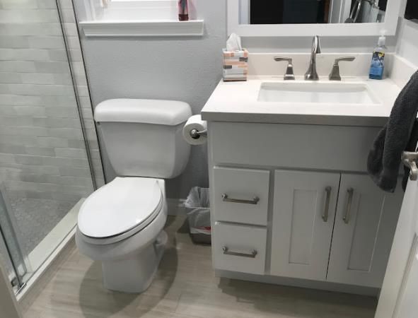 A bathroom with a toilet a sink and a mirror