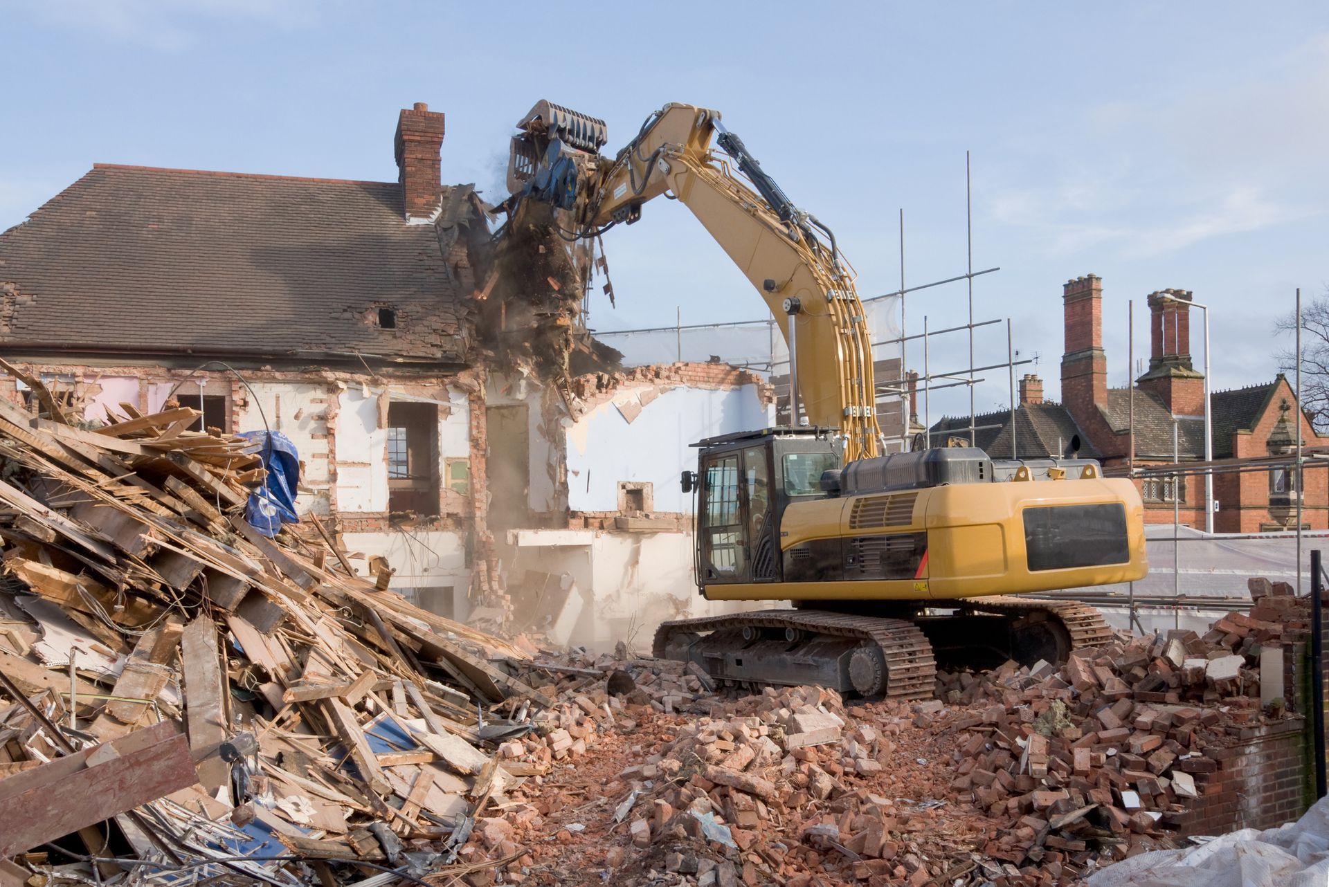 Dukes operates a bulldozer on a house demolition site in Amherst Town, MA, showcasing their expertis