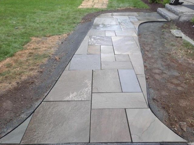 Stone walkway curving through green lawn.