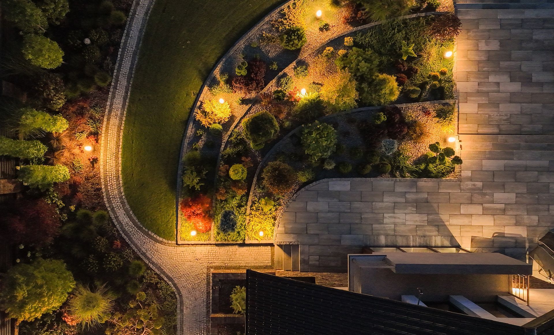An aerial view of a garden at night with lots of lights