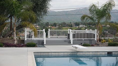 A swimming pool with a deck and stairs leading to it.