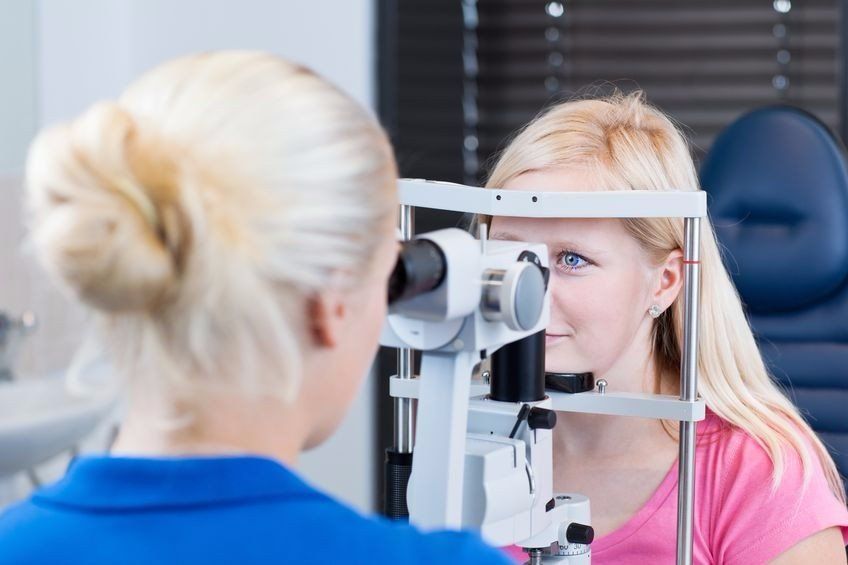 photo of an optometrist performing a slit-lamp biomicroscope exam on a patient
