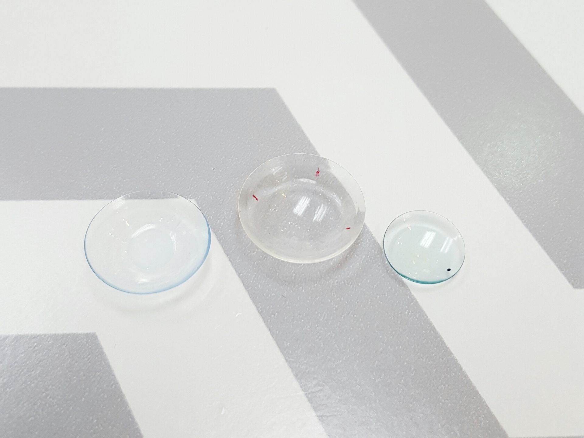 photo showing a size comparison of a soft contact lens, a scleral lens, and a traditional rgp lens