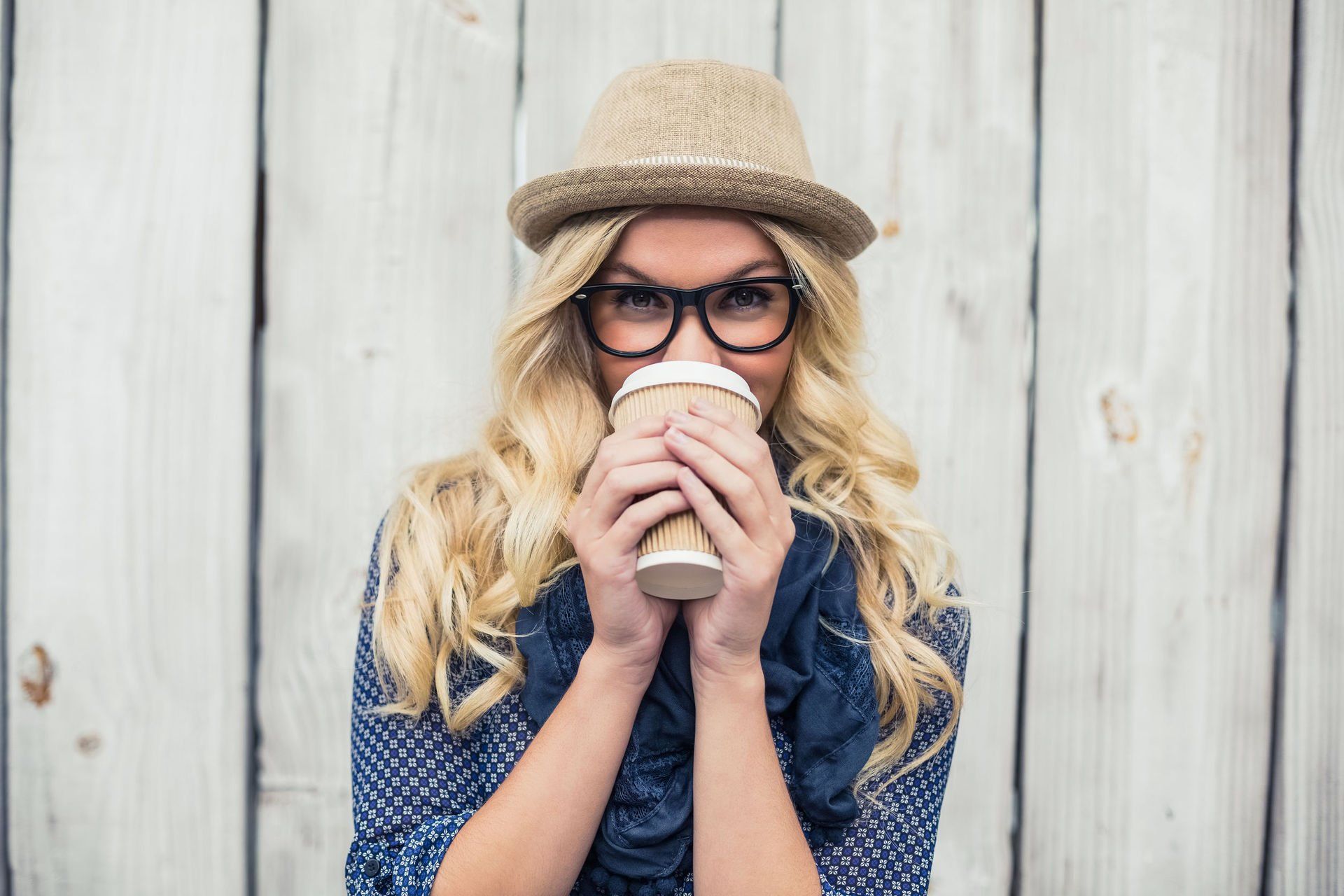 Woman wearing glasses and drinking coffee