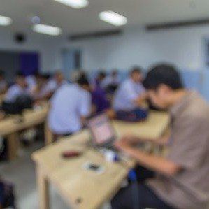 a group of people sitting at desks in a classroom