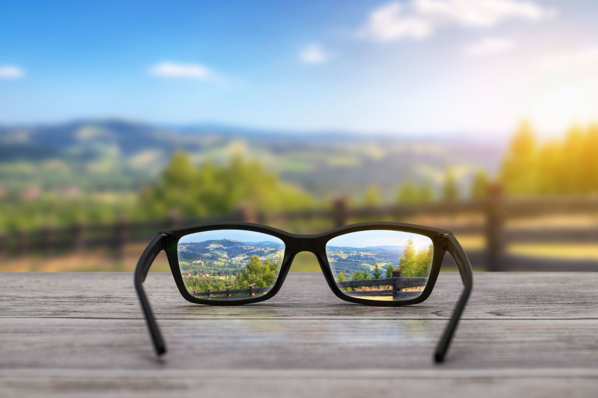 a pair of glasses showing corrected vision while objects in the distance are blurry