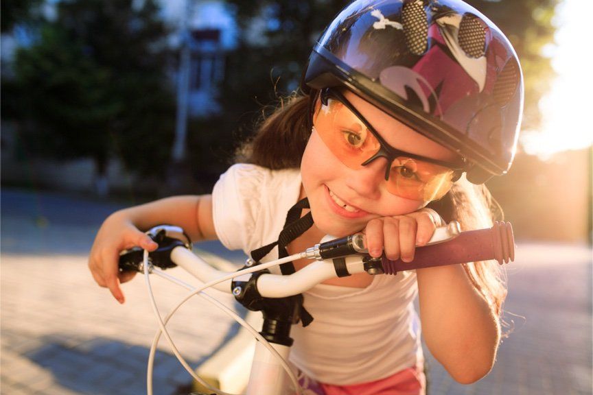 Young girl with protective eyewear on a bicycle