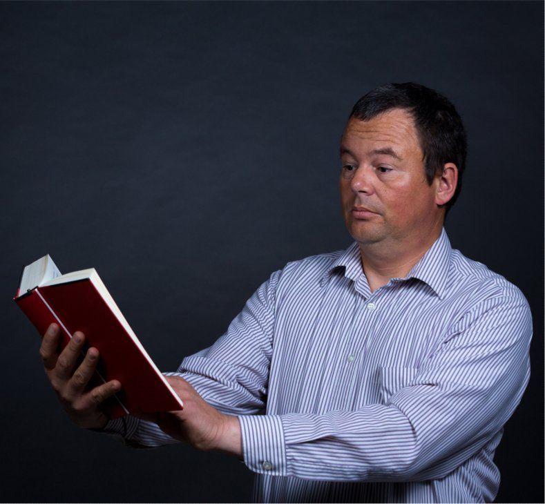 man holding a book at arms length
