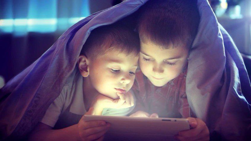 two young boys looking at a tablet