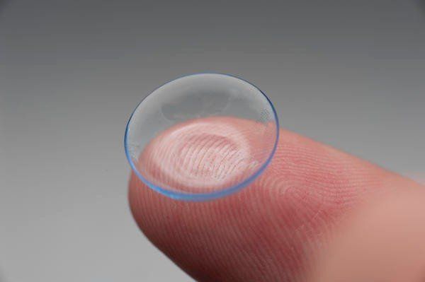 a hand holding a contact lens