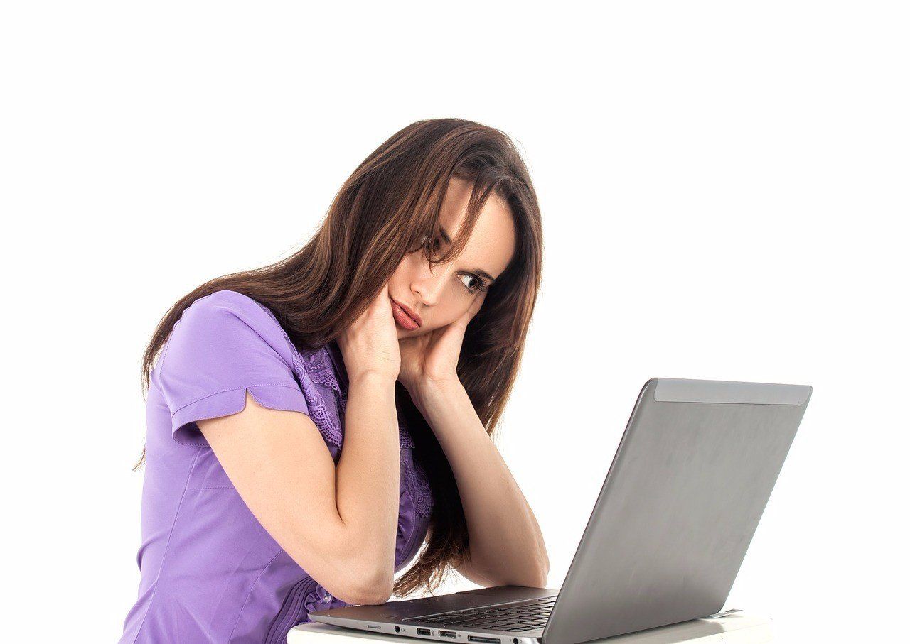 Girl appearing fatigued looking at a laptop computer