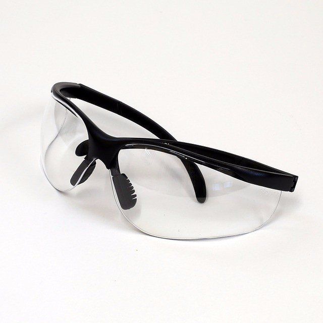 A pair of clear safety glasses with a black frame