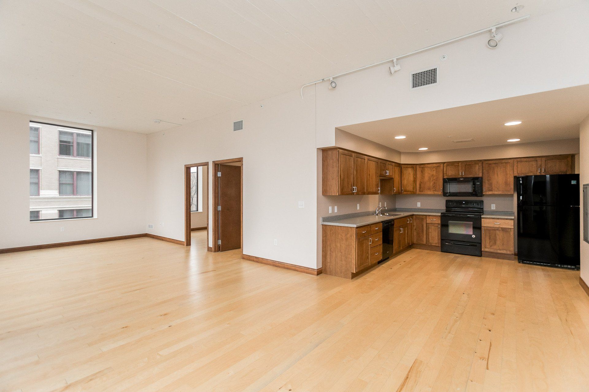 Interior of hard flooring with kitchen and bathroom in background