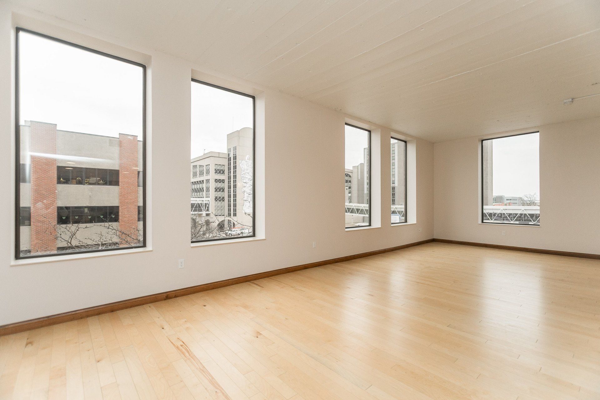 Interior with hardwood floors, and 5 large windows looking out
