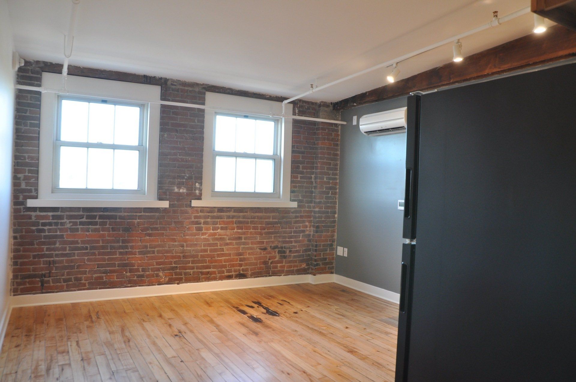 Interior of apartment with two windows and hardwood floors