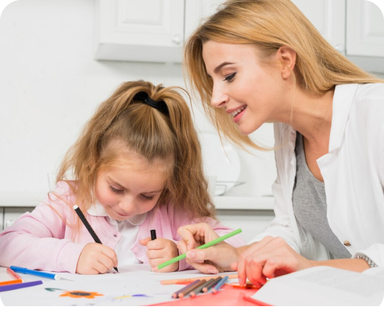 A woman and a little girl are sitting at a table drawing with markers.