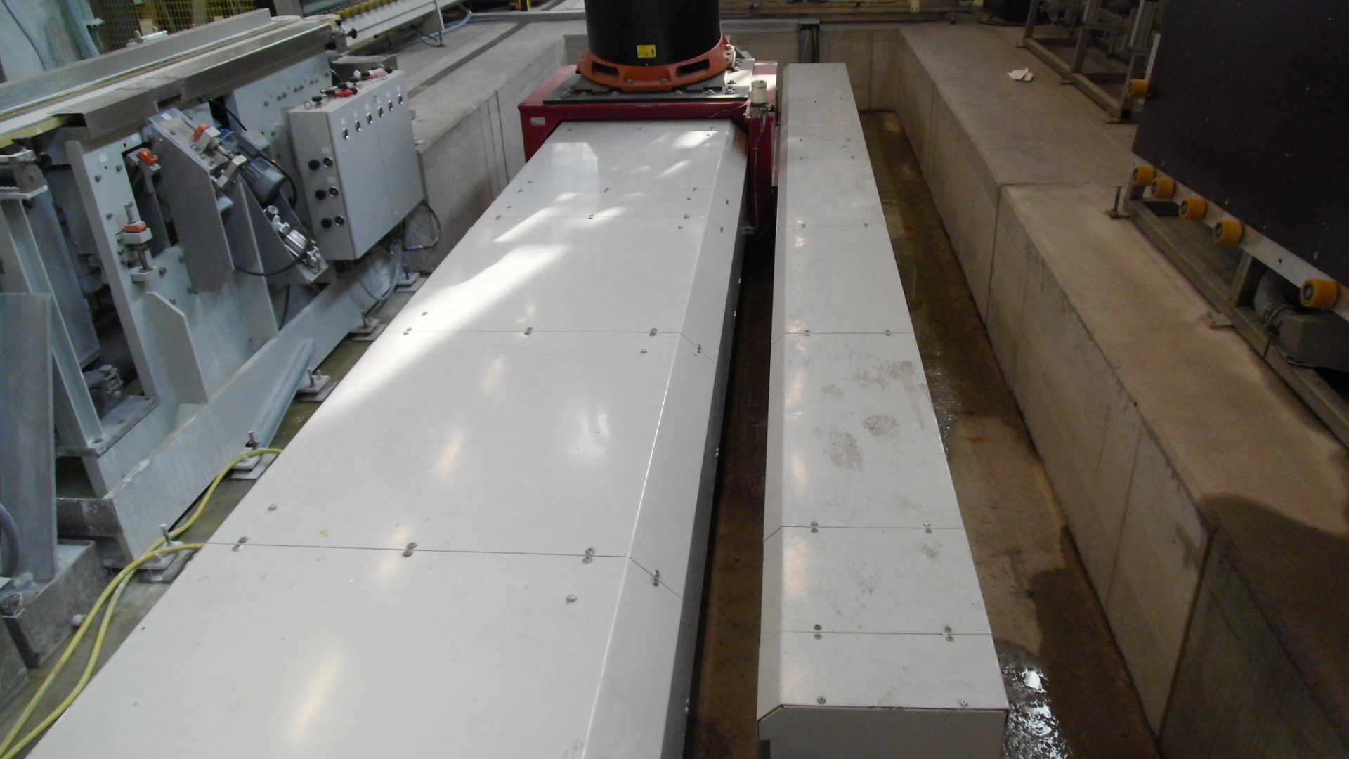 A machine is cutting a piece of concrete in a factory.