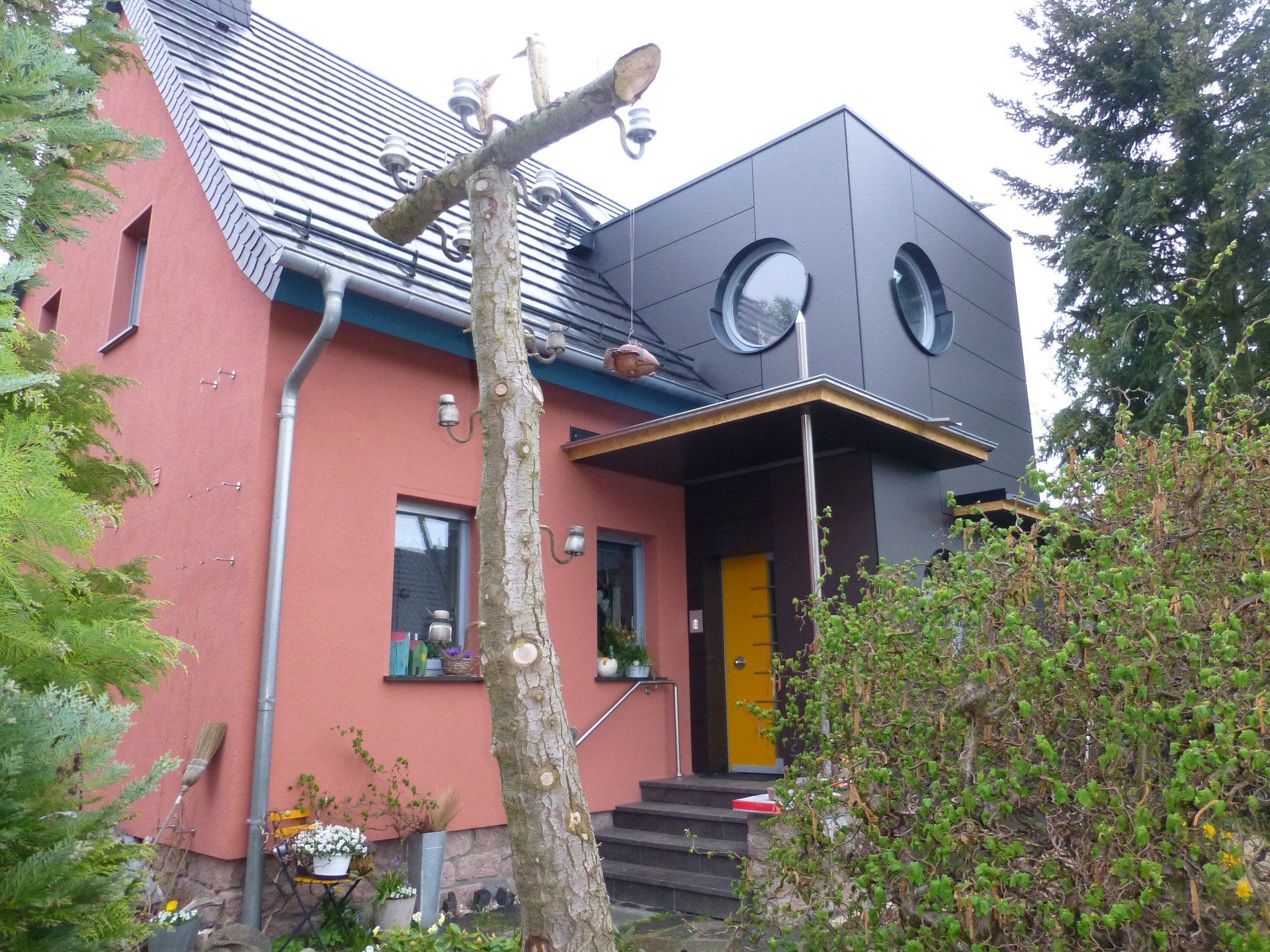 A red house with a black roof and a yellow door