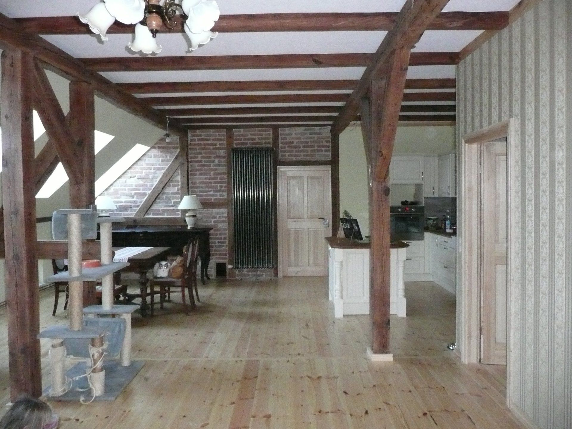 A room with wooden beams and a brick wall
