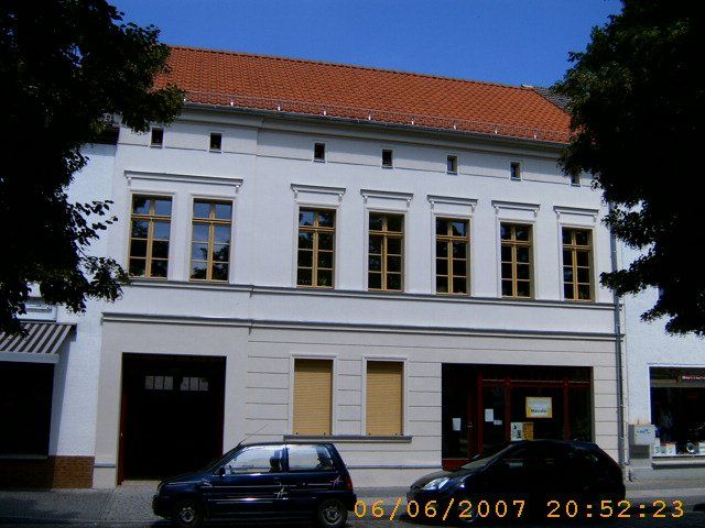 A car is parked in front of a large white building