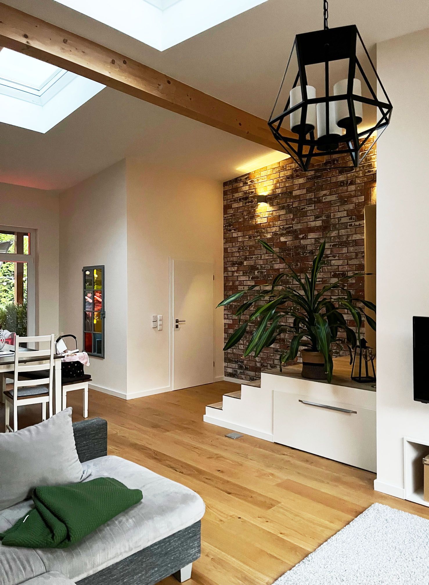 A living room with hardwood floors and a brick wall