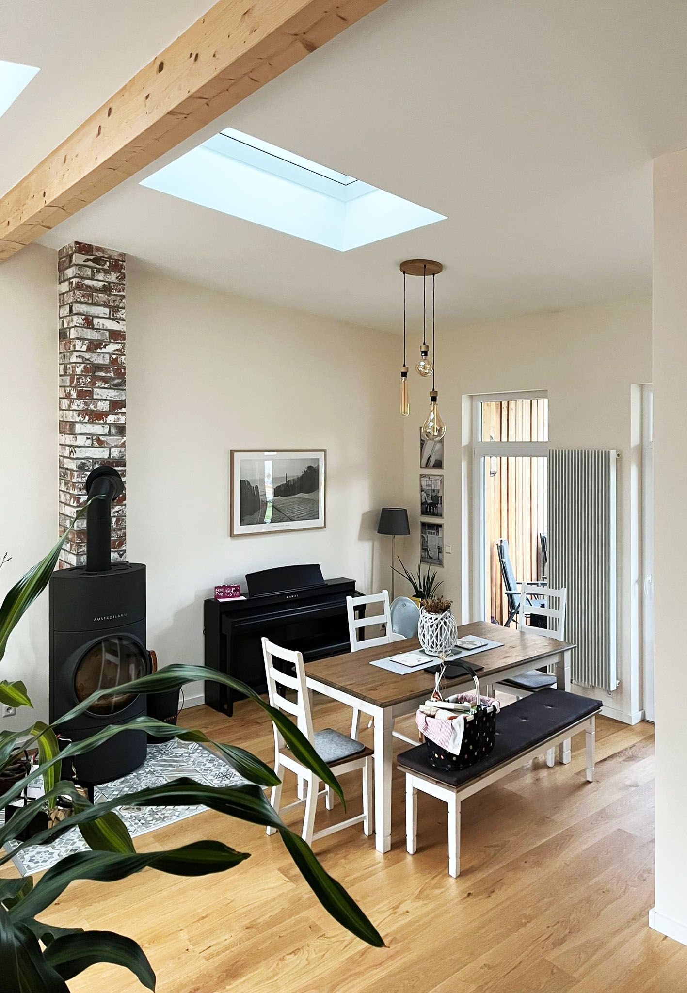 A living room with a table and chairs and a skylight.