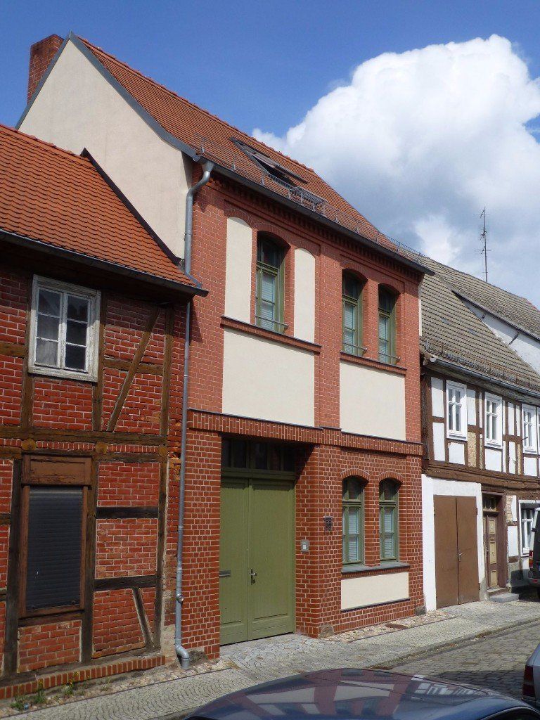 A car is parked in front of a brick building