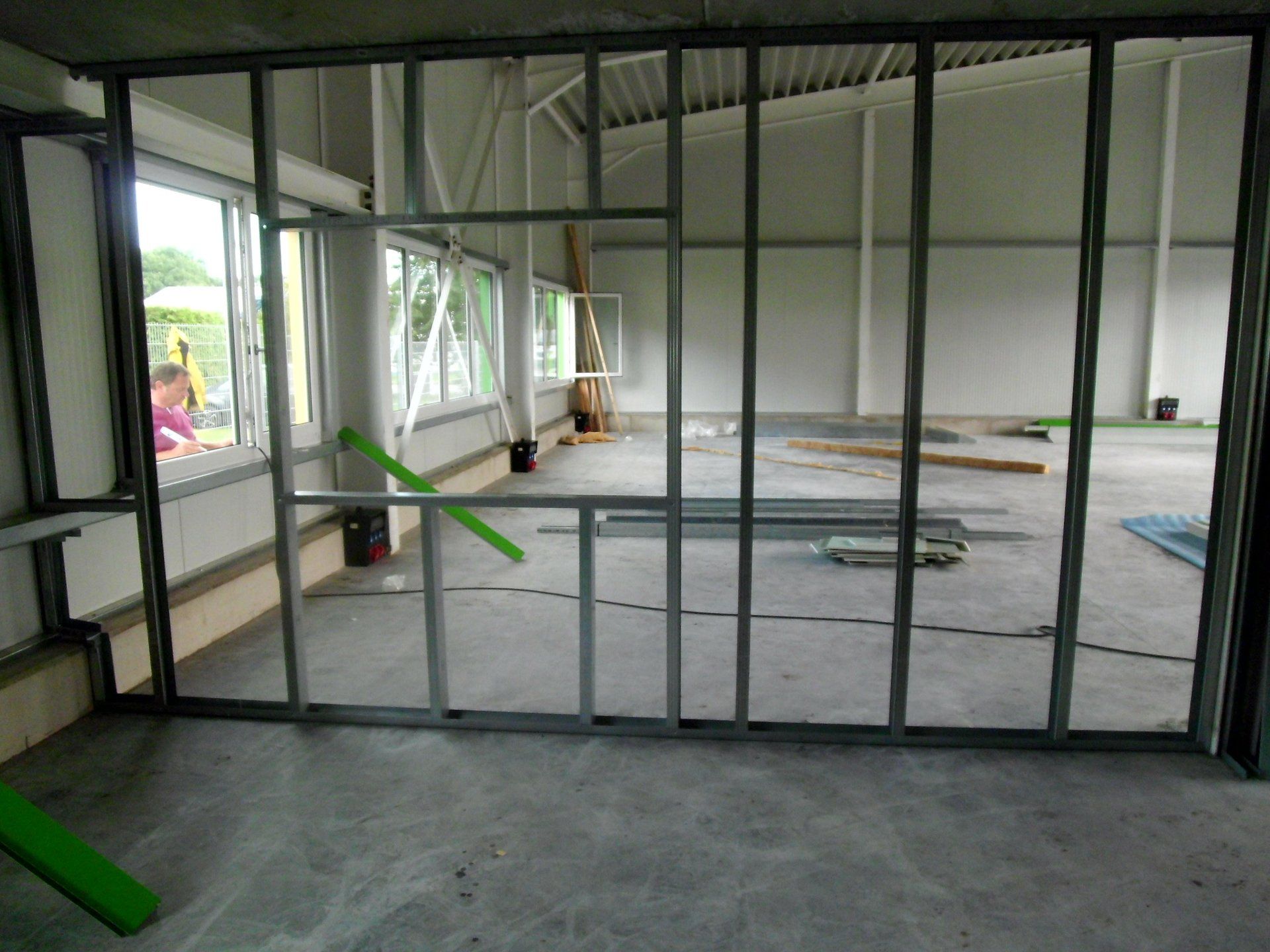 An empty room with a green arrow pointing to a window