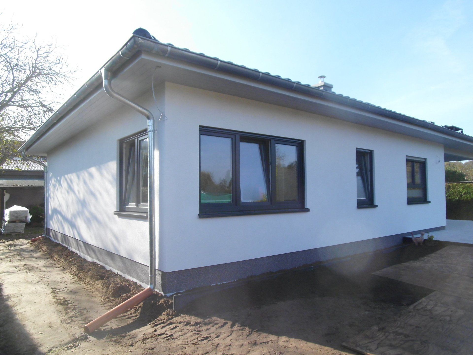 A white house with black windows and a gutter