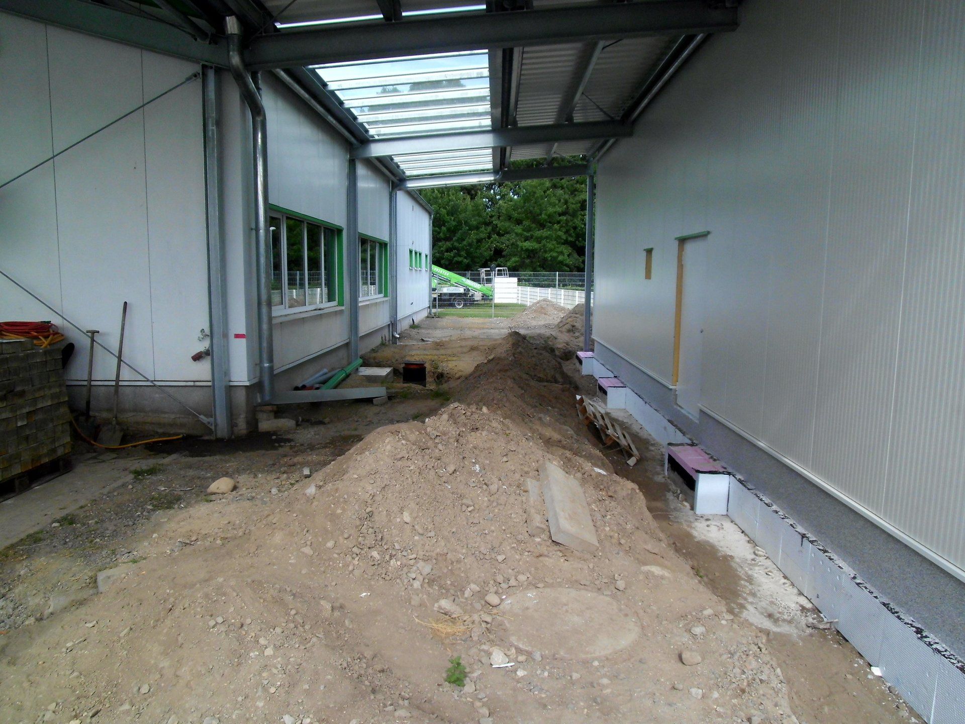 A pile of dirt is in front of a white building