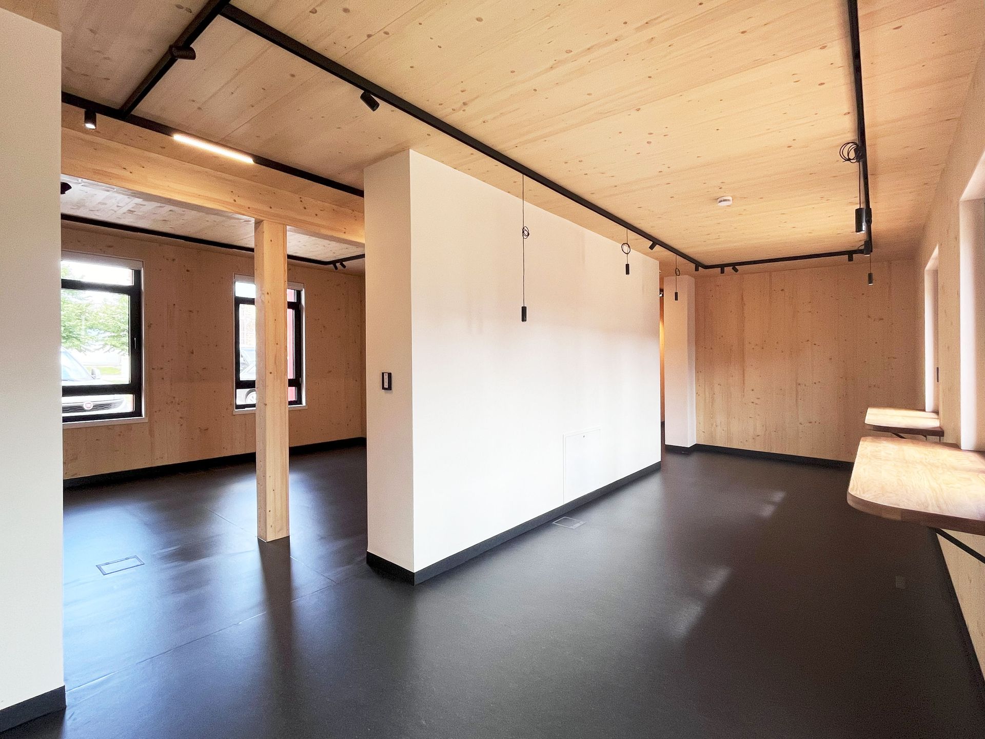 Ein leerer Raum mit einer Holzdecke und einem schwarzen Boden