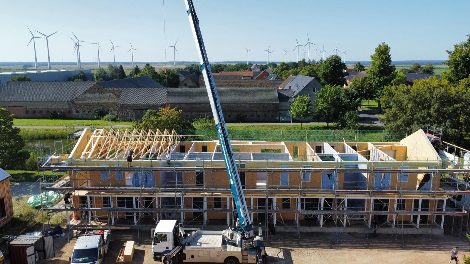 Eine Luftaufnahme eines im Bau befindlichen Gebäudes mit einem Kran im Vordergrund.