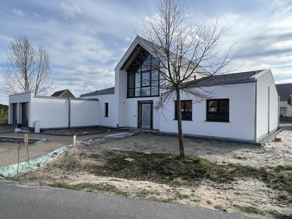 A white house with a tree in front of it.