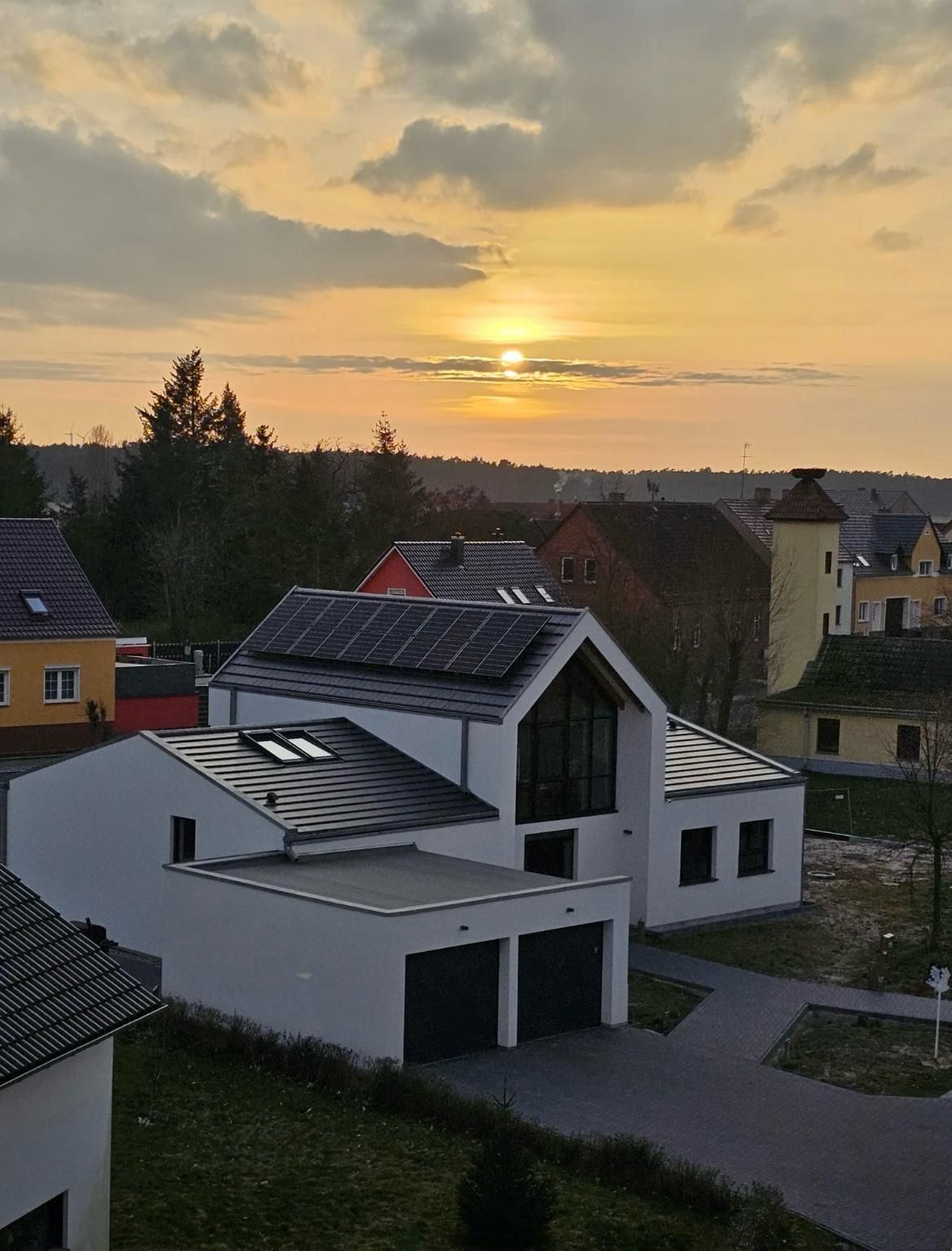 A house with solar panels on the roof at sunset