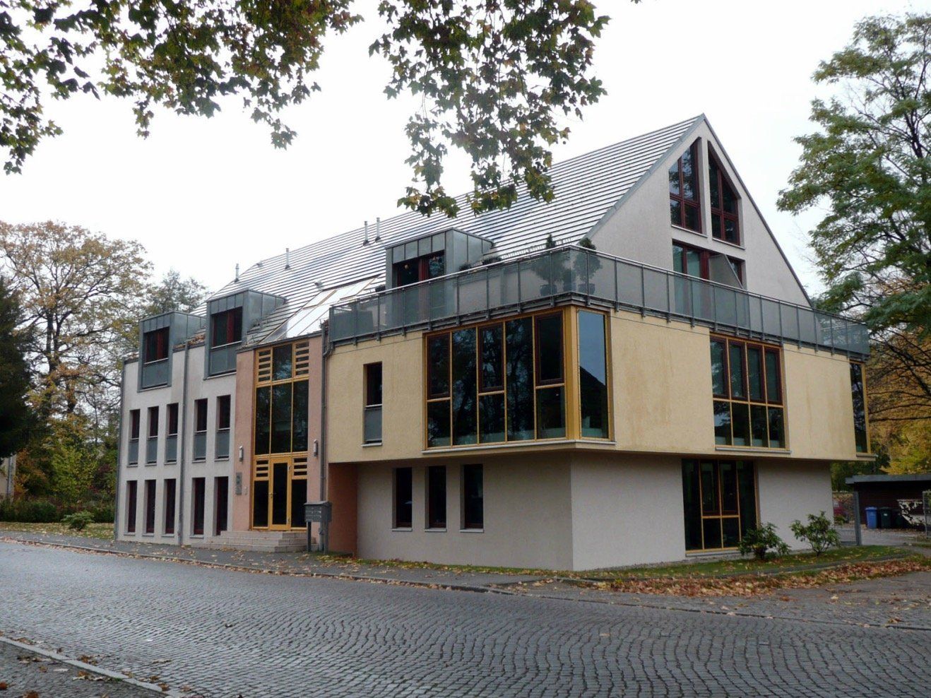 A large building with a lot of windows is surrounded by trees