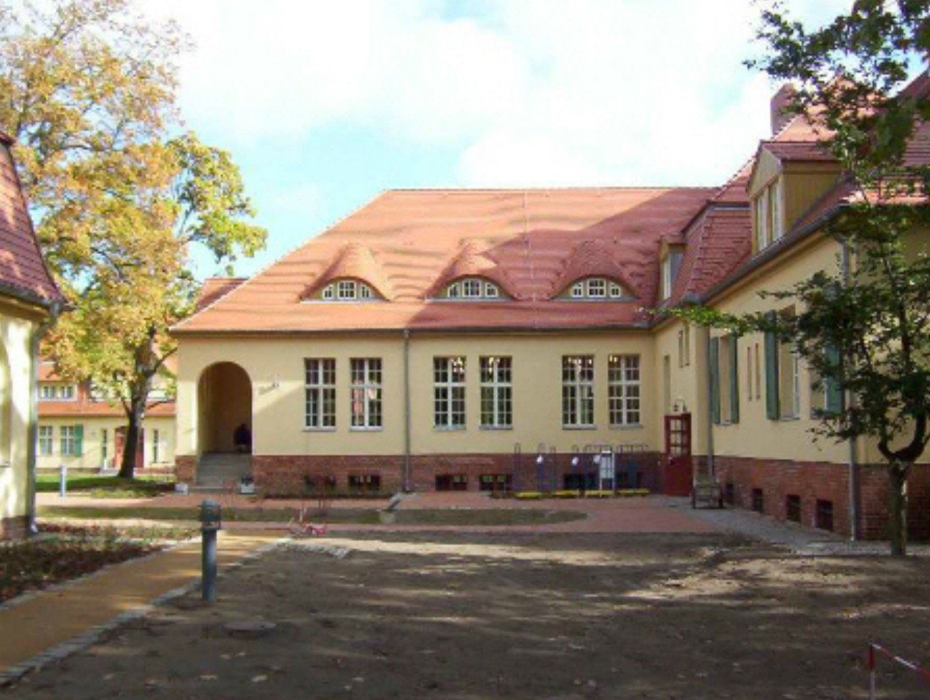 A large yellow building with a red tile roof