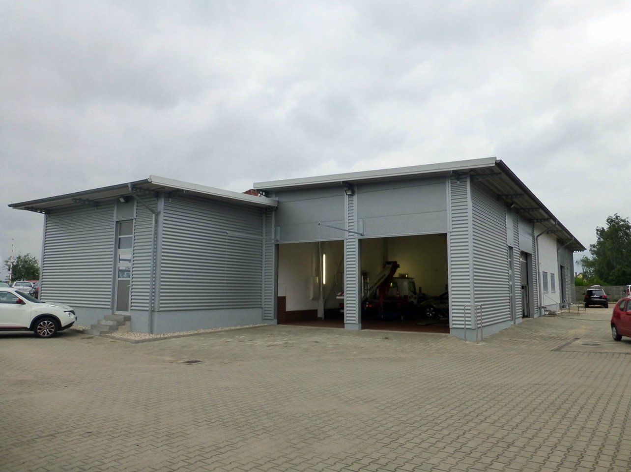 A garage with a lot of cars parked in front of it.