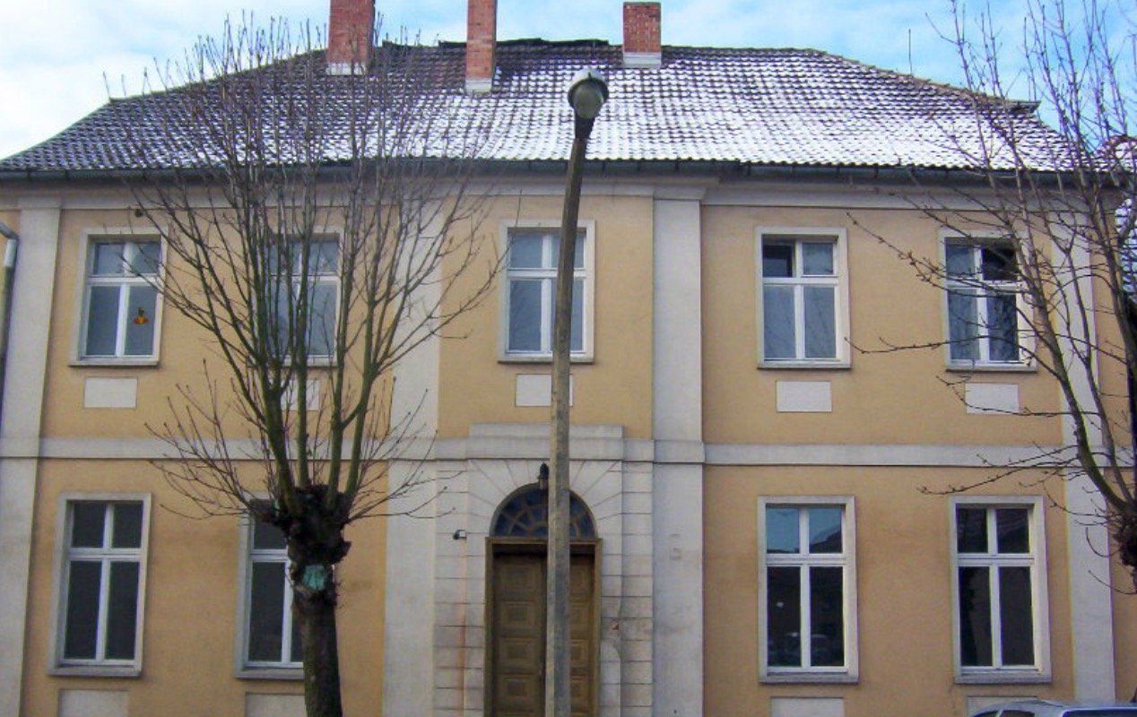 A large yellow building with a snowy roof
