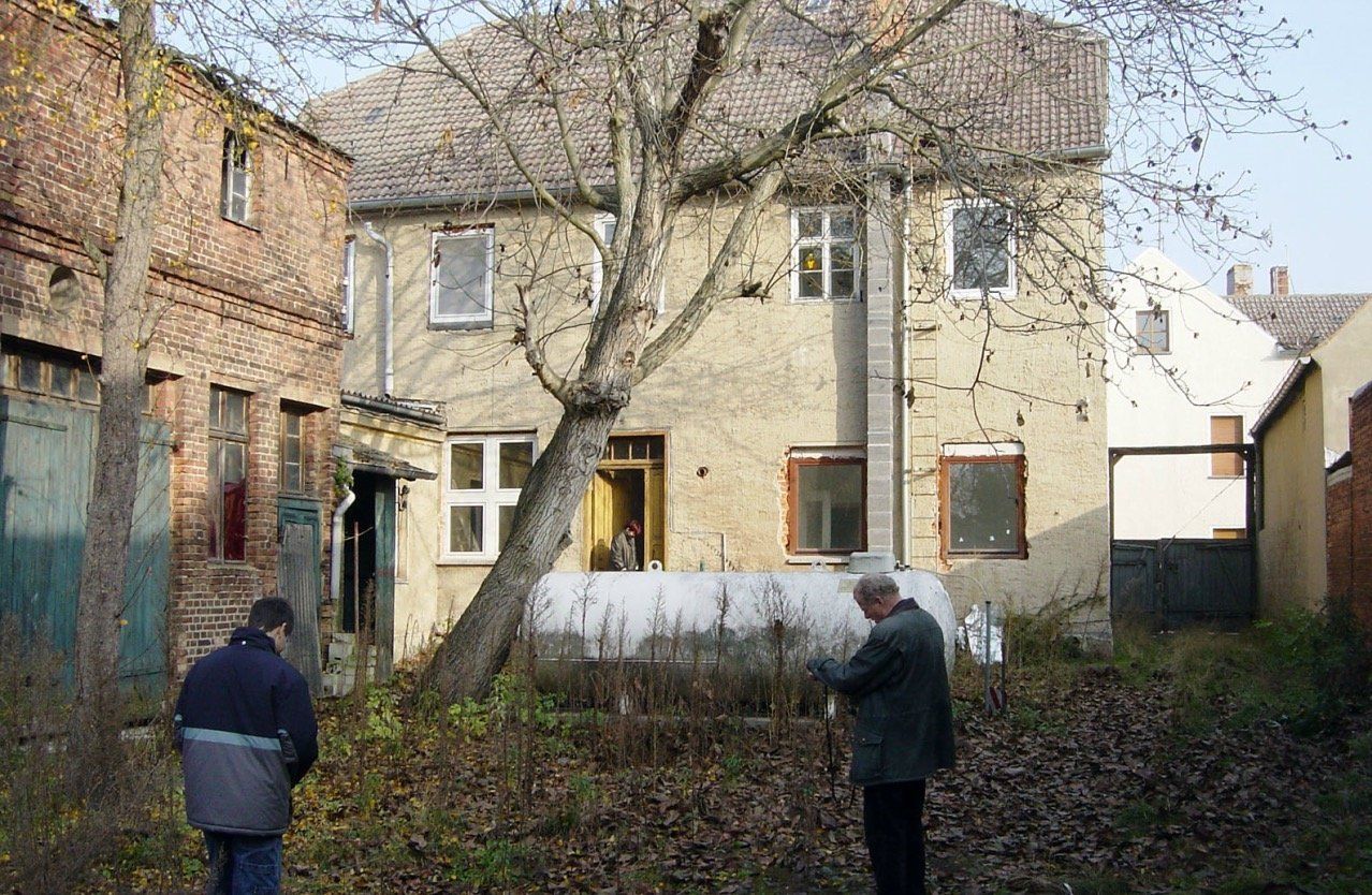 Two men are standing in front of an old building