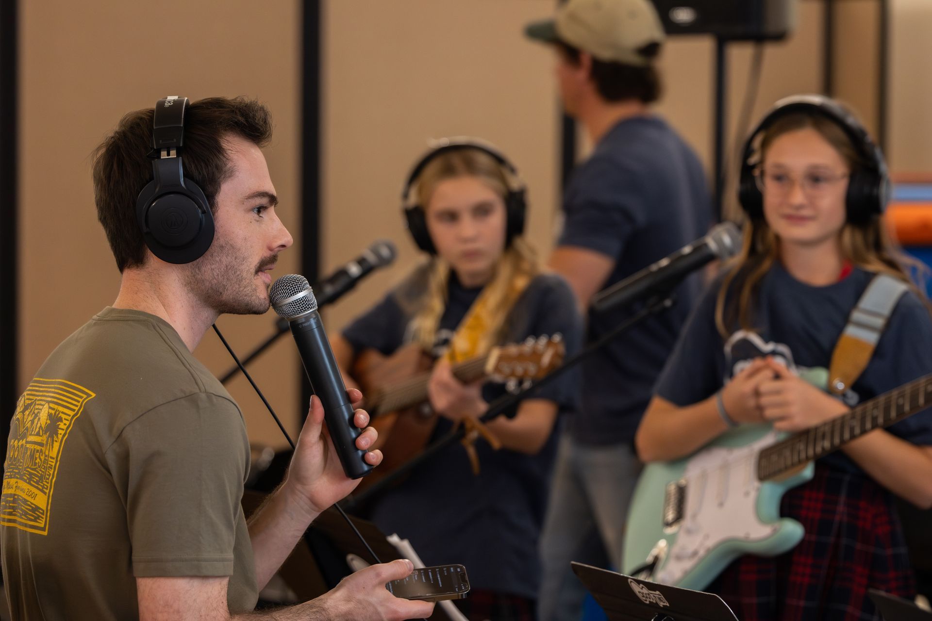 Band leader on the microphone teaching band practice students.