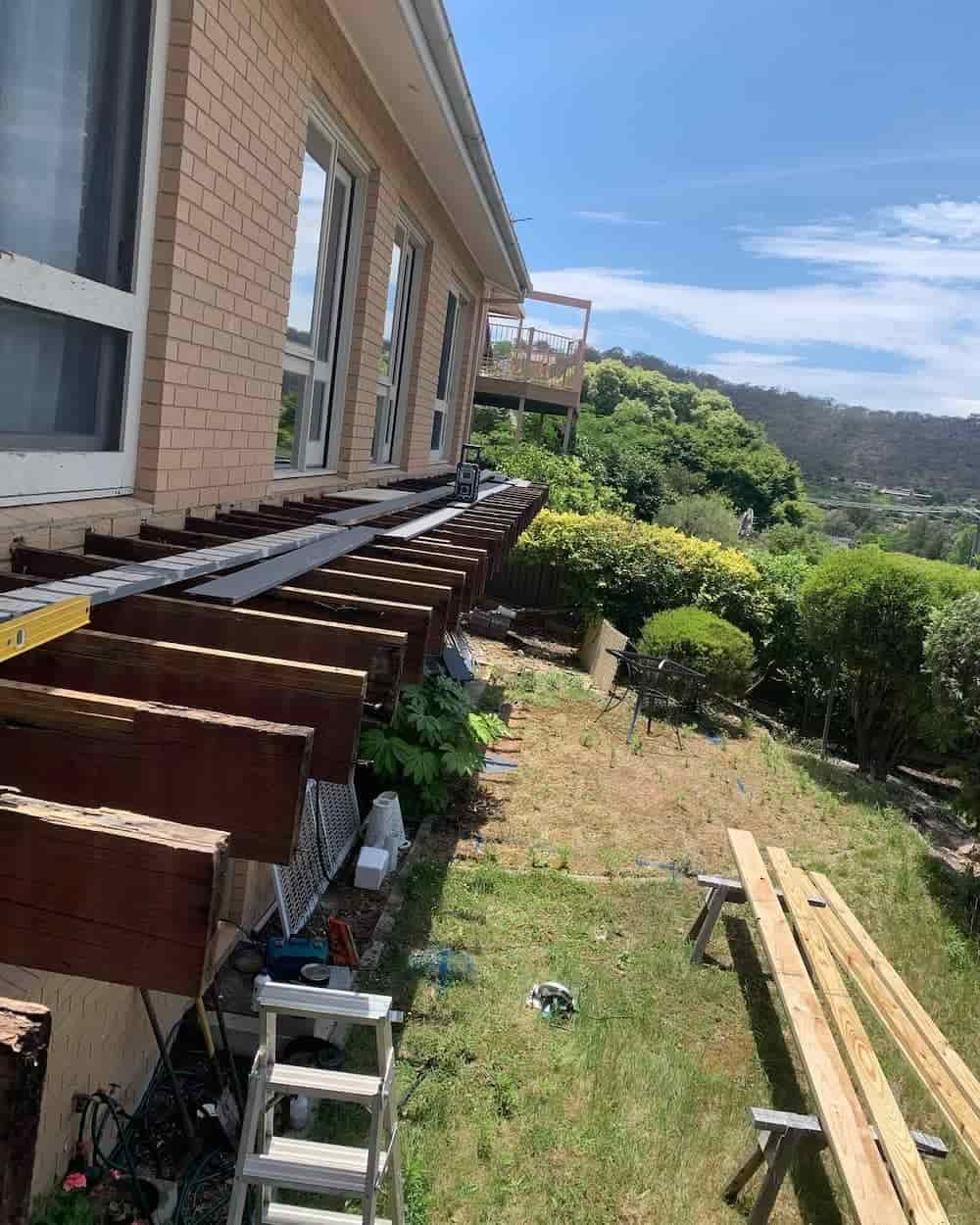 A Wooden Pergola Is Being Built On The Side Of A House — Renovo Contractors In Monash, ACT
