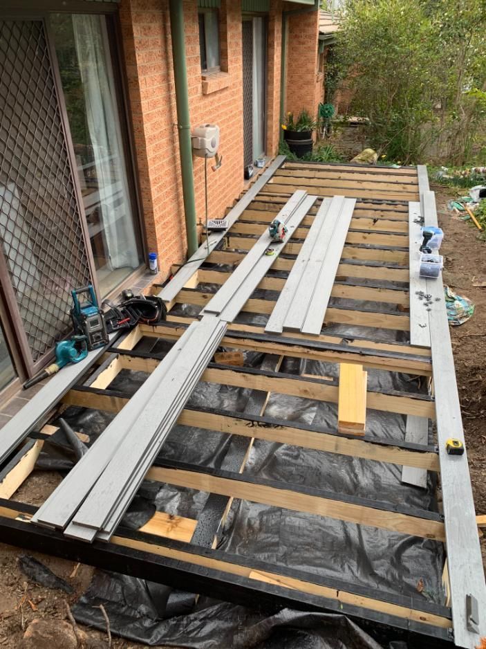 A Wooden Deck Is Being Built In Front Of A Brick House — Renovo Contractors In Monash, ACT