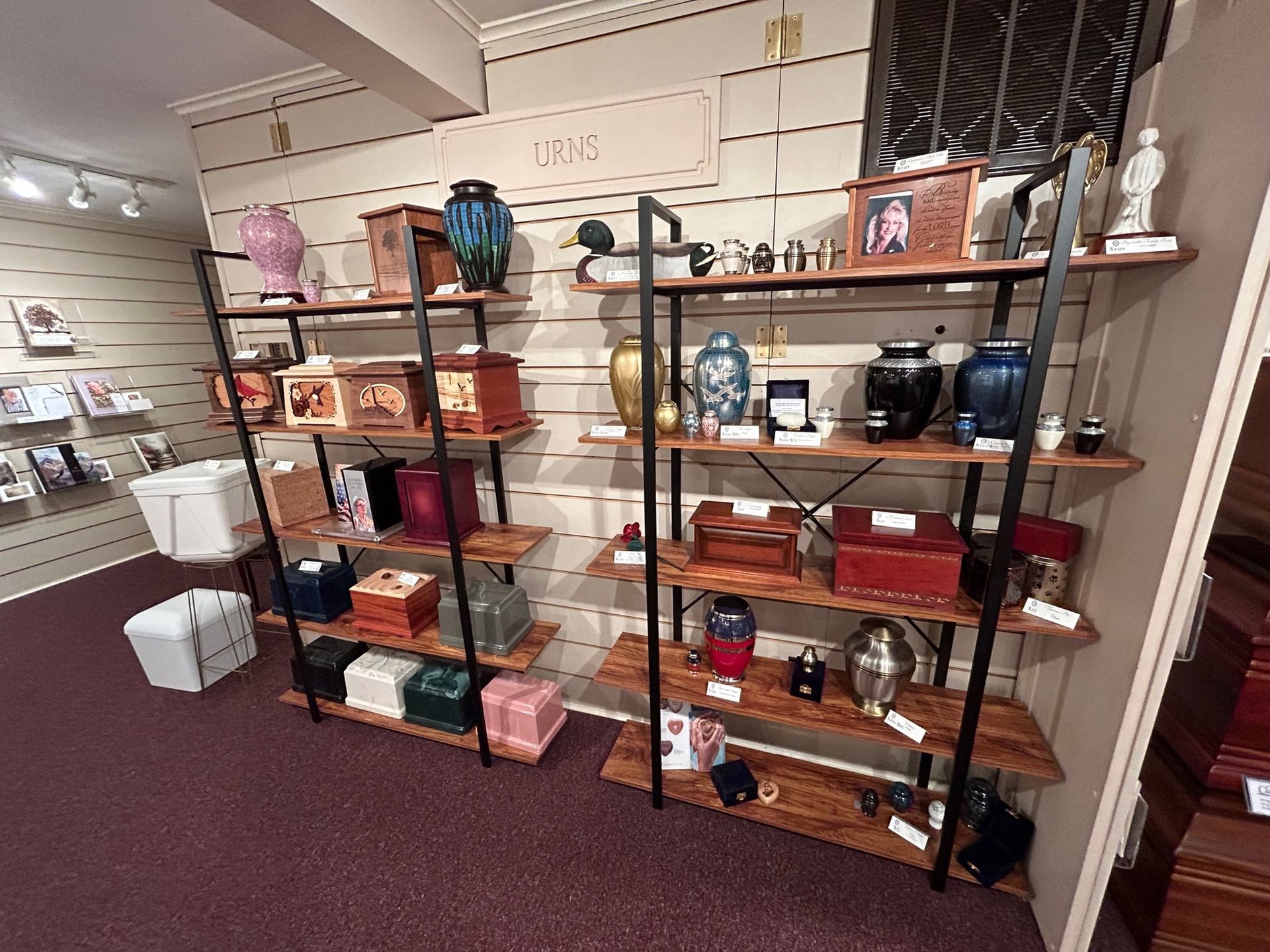 Shelves displaying various urns for sale in a store.