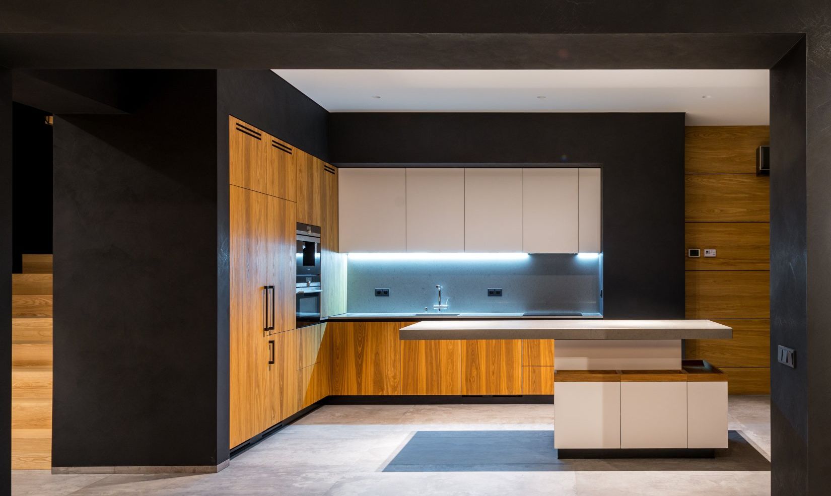 A modern kitchen with wooden cabinets , white cabinets , stainless steel appliances and a large island.