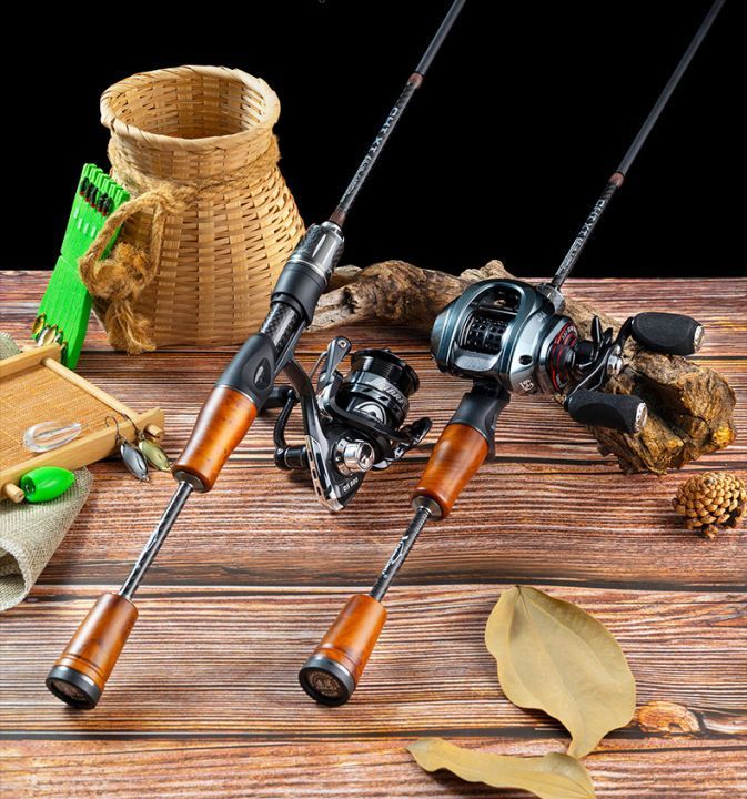 Two fishing rods and a fishing reel are on a wooden table.