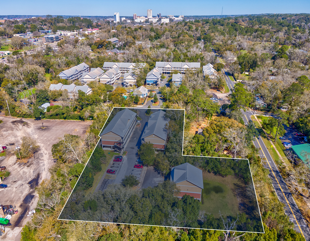 An aerial view of a residential area with a city in the background.